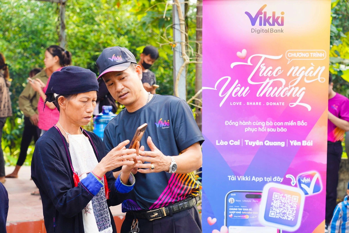 A woman from a mountainous province in northern Vietnam receives instructions from a Vikki Bank representative on using the bank's app on her mobile phone. Photo: Vikki Bank