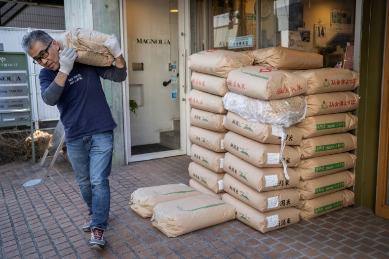 The owner of rice shop Tadao Koike carries a bag of rice at his shop in Tokyo on February 14, 2025. Photo: AFP