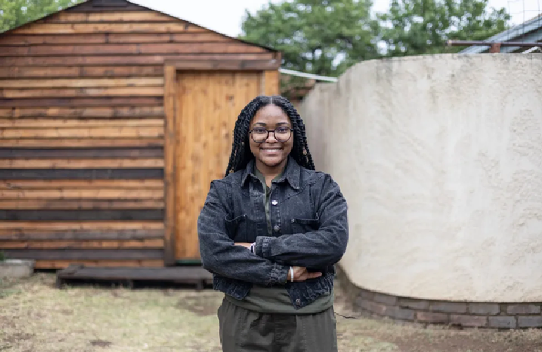 Palesa Molefe, 22, a fourth year Bachelor of Science student in the Climate Change department at the University of the Witwatersrand, outside her house in Sharon Park. Photo: AFP