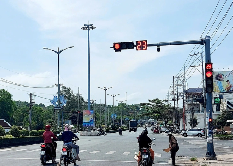 A person stands at a red light in An Thoi Ward, Phu Quoc City to ask for money despite the scorching weather. Photo: Chi Cong / Tuoi Tre