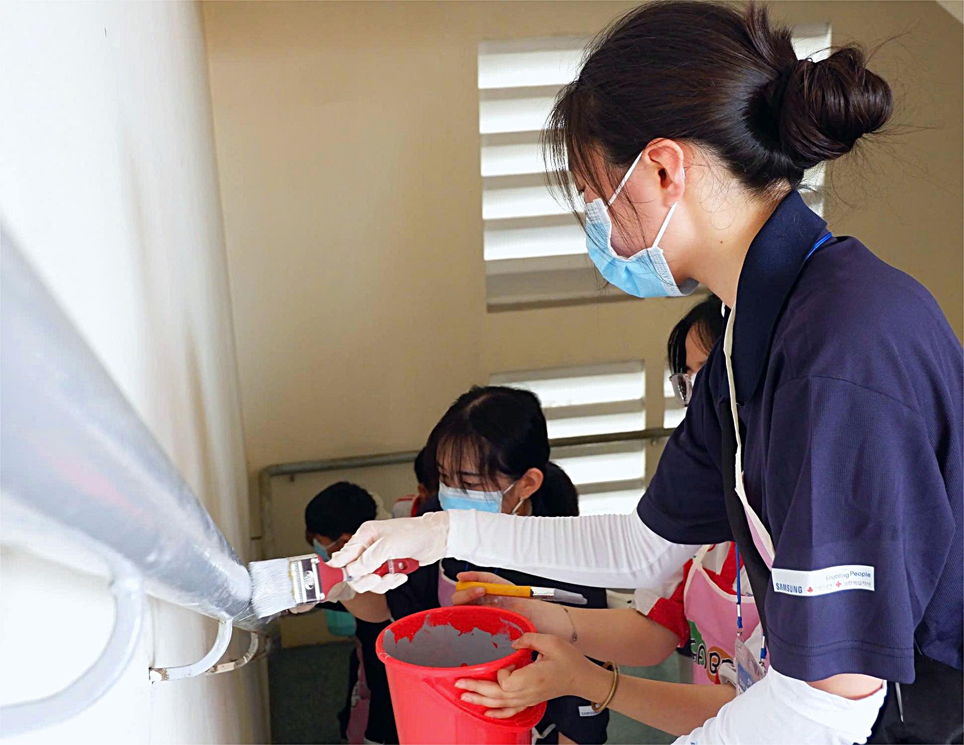 Vietnamese and South Korean Red Cross volunteers jointly repaint stair railings at Dao Son Tay High School in Thu Duc City, Ho Chi Minh City as part of a week-long exchange program from February 16 to 23, 2025 in Ho Chi Minh City. Photo: K.A.