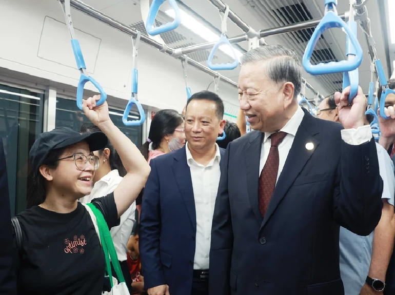 Party General Secretary To Lam (R) talks with a passenger on a train of the first metro line in Ho Chi Minh City. Photo: Vietnam News Agency