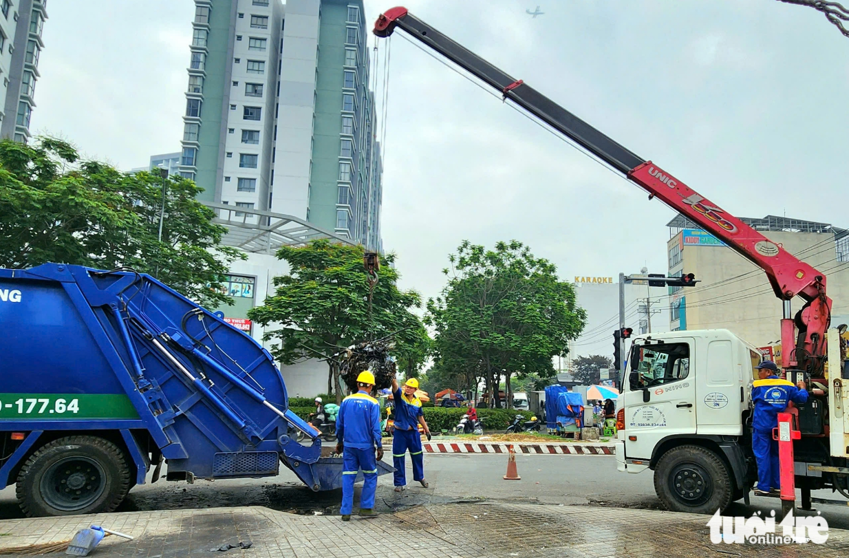 A trash truck and a crane are stationed at a canal in Ho Chi Minh City for the cleanup. Photo: Ngoc Khai / Tuoi Tre