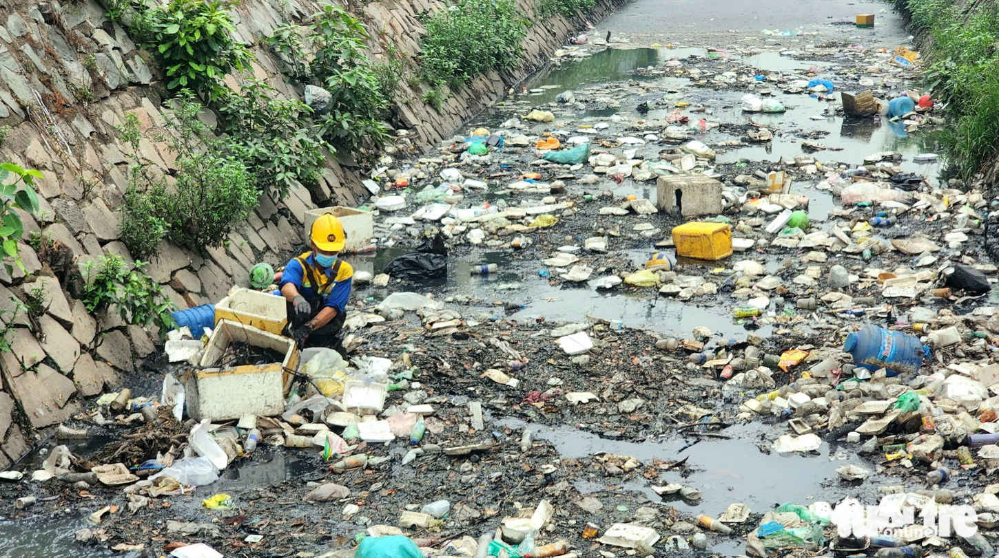 A sanitation worker collects waste in a section of Canal 19/5 in Tan Phu District, Ho Chi Minh City on February 22, 2025. Photo: Ngoc Khai / Tuoi Tre