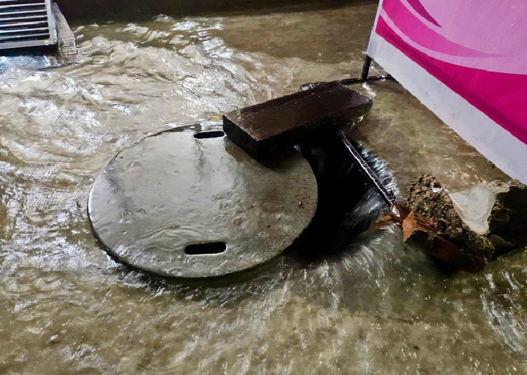 People uncovered manholes yet the water still drained slowly. Photo: Minh Chien / Tuoi Tre