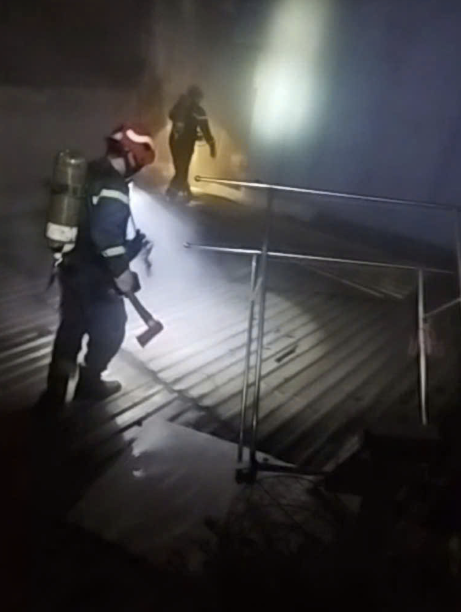 Firefighters access the roof of a bakery to break windows and doors to rescue people trapped in a fire in downtown Ho Chi Minh City. Photo: Supplied