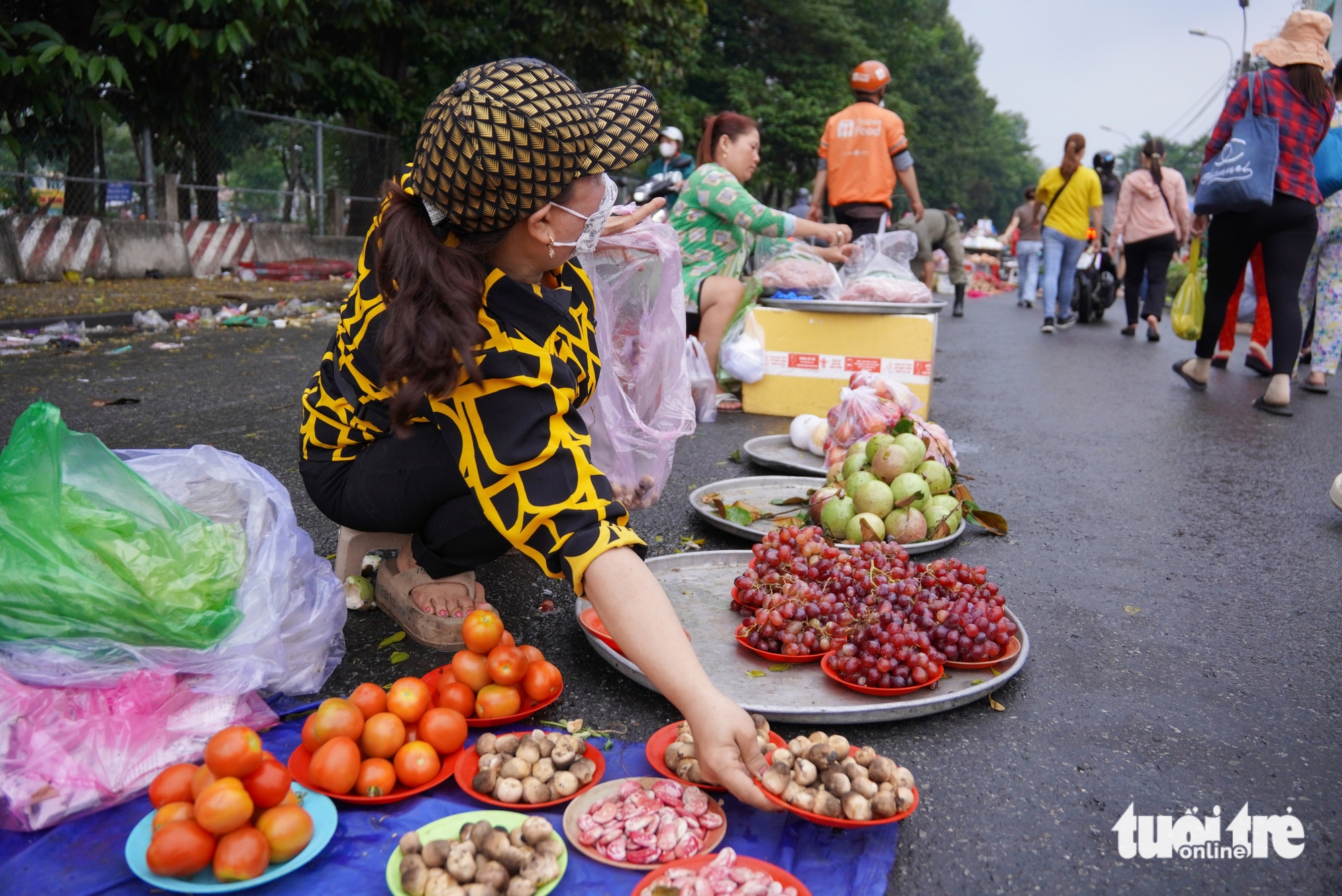 Be sells vegetables and fruits on small plates at Tan Tao makeshift market in Tan Tao Ward, Tan Binh District, Ho Chi Minh City. Photo: An Vi / Tuoi Tre