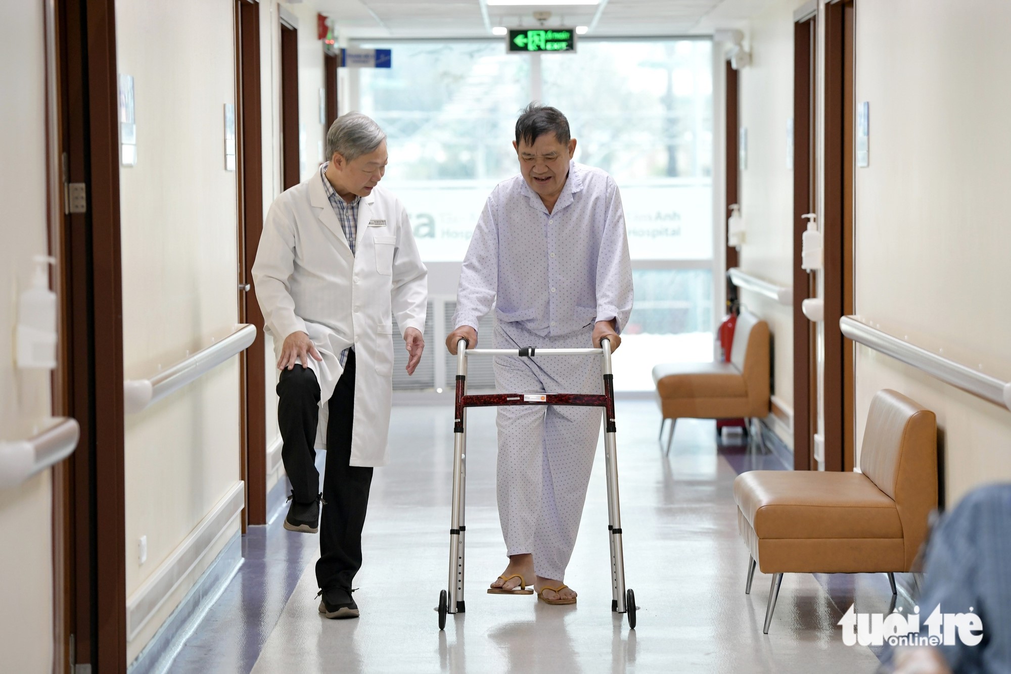 He guides patients in relearning how to walk post-surgery. Photo: Duyen Phan / Tuoi Tre