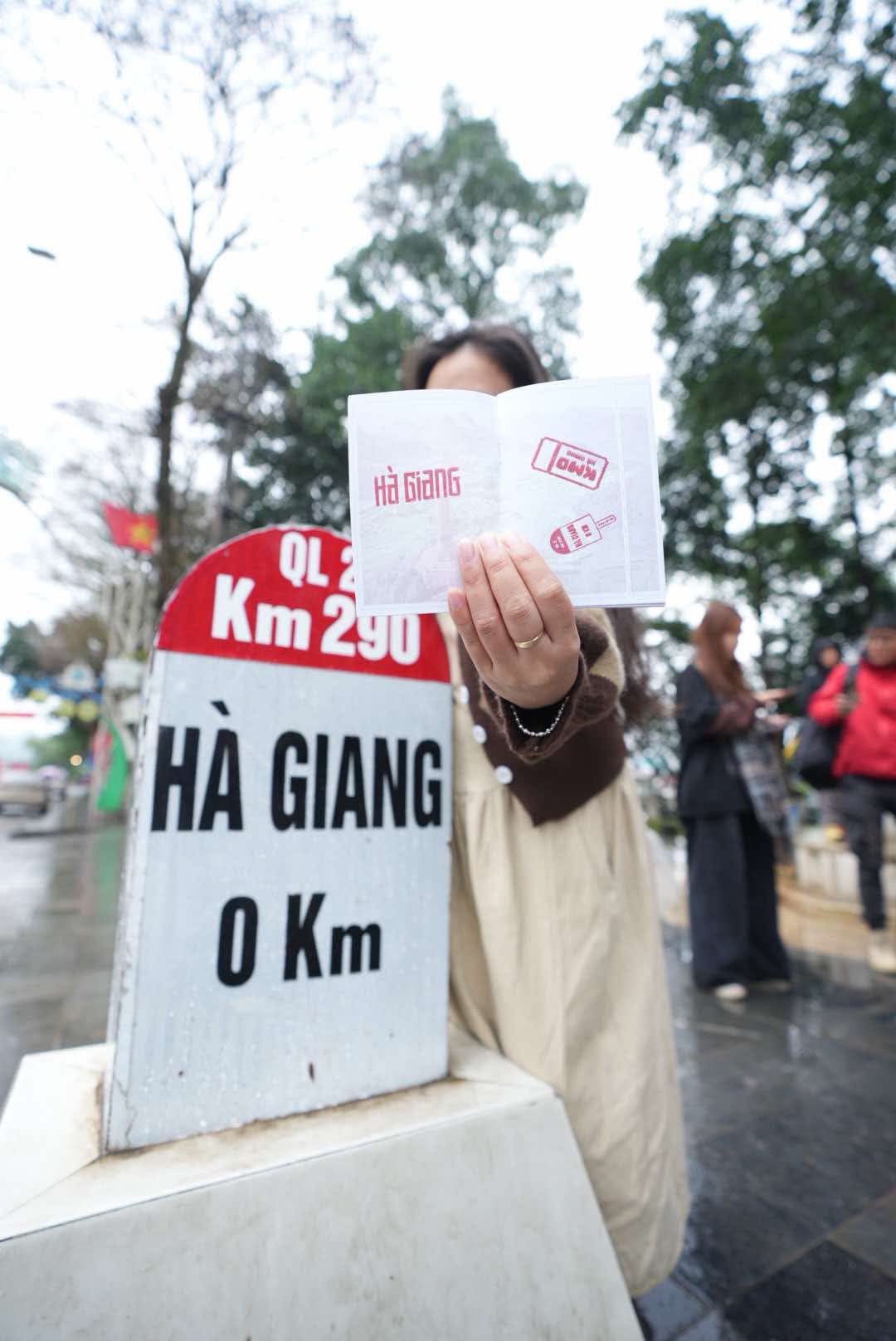 A tourist shows the ‘Ha Giang Passport’ at the Km0 milestone in Ha Giang City, Ha Giang Province, northern Vietnam. Photo: Hung Vi