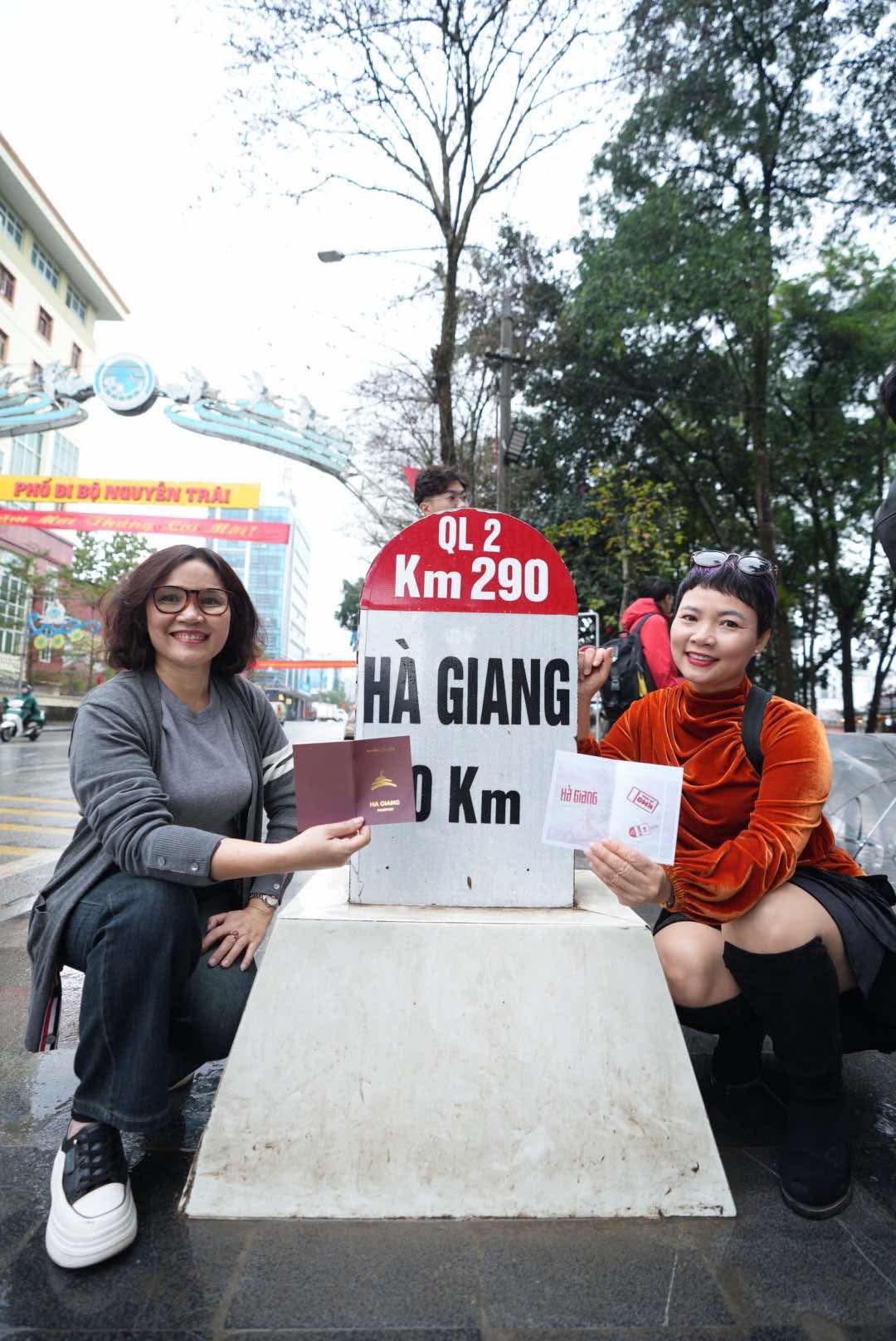 Tourists show the ‘Ha Giang Passports’ at the Km0 milestone in Ha Giang City, Ha Giang Province, northern Vietnam. Photo: Hung Vi