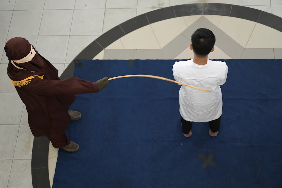 A man convicted of having same sex relationship is publicly caned by a Sharia Law official in Banda Aceh, Indonesia, February 27, 2025. Photo: Reuters