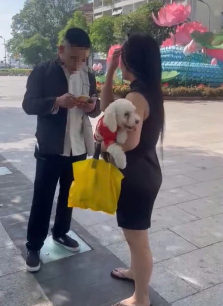 A still image taken from a clip shows a couple with an unmuzzled dog. The two get involved in an attack on a security guard on Nguyen Hue Pedestrian Street in downtown Ho Chi Minh City after being reminded not to let the dog run loose.