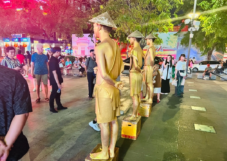 Many people observe living statues on Nguyen Hue Pedestrian Street in Ho Chi Minh City, but some touch or tease the ‘statues’. Photo: May Trang