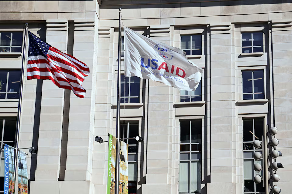 An American flag and USAID flag fly outside the USAID building in Washington, D.C., U.S., February 1, 2025. Photo: Reuters