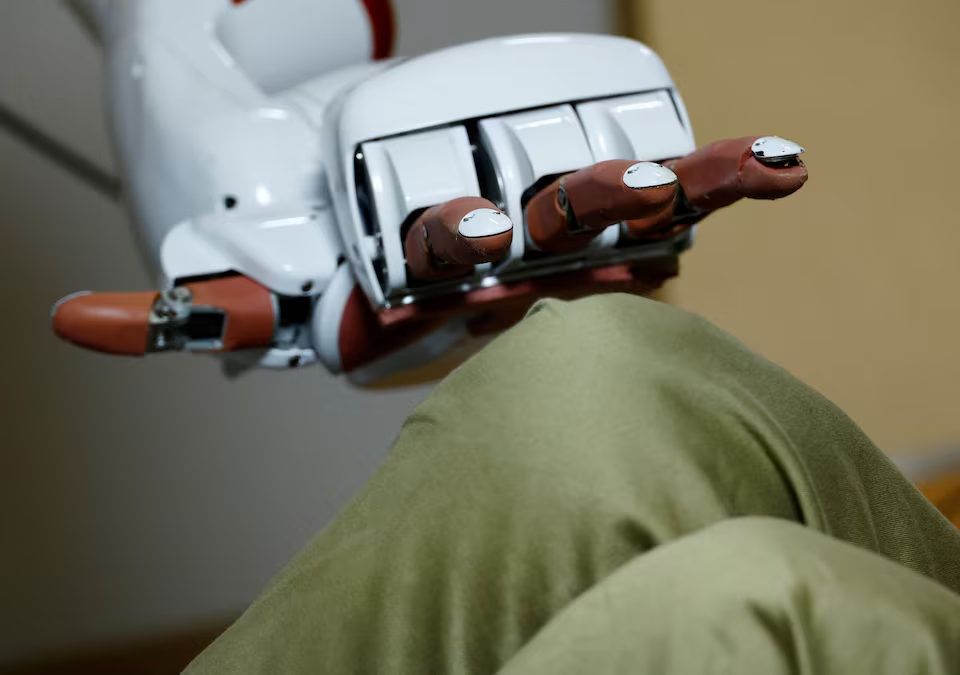 AIREC, an artificial intelligence (AI)-driven humanoid robot, demonstrates a manoeuvre for changing diapers or preventing bedsores with a researcher at Waseda University's laboratory in Tokyo, Japan February 17, 2025. Photo: Reuters