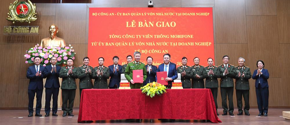 Deputy Minister of Public Security Nguyen Ngoc Lam (first row, L) and Commission for the Management of State Capital at Enterprises (CMSC) Vice-chairman Nguyen Ngoc Canh (first row, R), sign a deal to transfer state ownership of MobiFone from CMSC to the Ministry of Public Security, Hanoi, February 28, 2025. Photo: Vietnam’s Ministry of Public Security