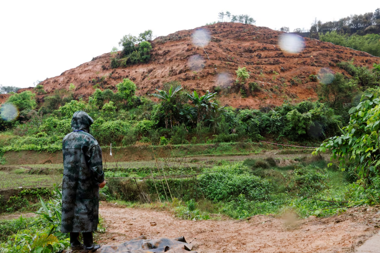 A person stands in the rain at the site where a China Eastern Airlines Boeing 737-800 plane flying from Kunming to Guangzhou crashed, in Wuzhou, Guangxi Zhuang Autonomous Region, China March 24, 2022. Photo: Reuters