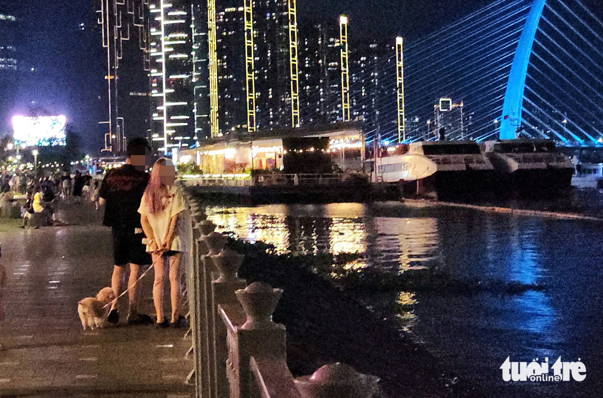 A girl lets a leashed dog down onto the ground at Bach Dang Wharf Park in District 1, Ho Chi Minh City, February 27, 2025. Photo: Ngoc Khai / Tuoi Tre