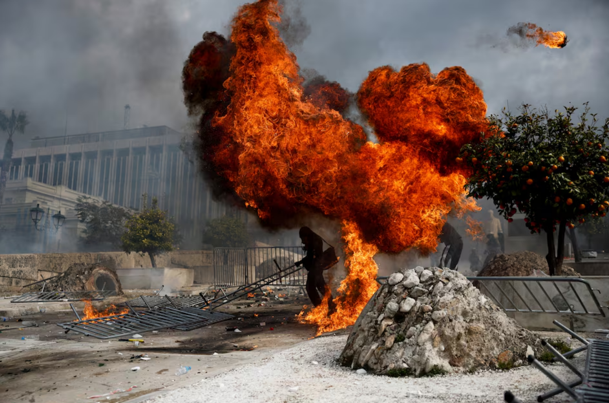 Demonstrators stand next to fire during clashes near the Greek parliament at a protest marking the second anniversary of the country's worst railway disaster, in Athens, February 28. Photo: Reuters