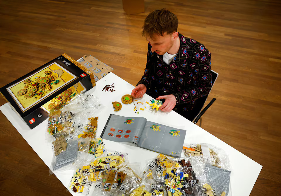 [14/15]LEGO Product Designer Stijn Oom puts bricks together to assemble a LEGO brick version of Van Gogh's Sunflowers painting at Van Gogh Museum in Amsterdam, Netherlands, February 28, 2025. Photo: Reuters