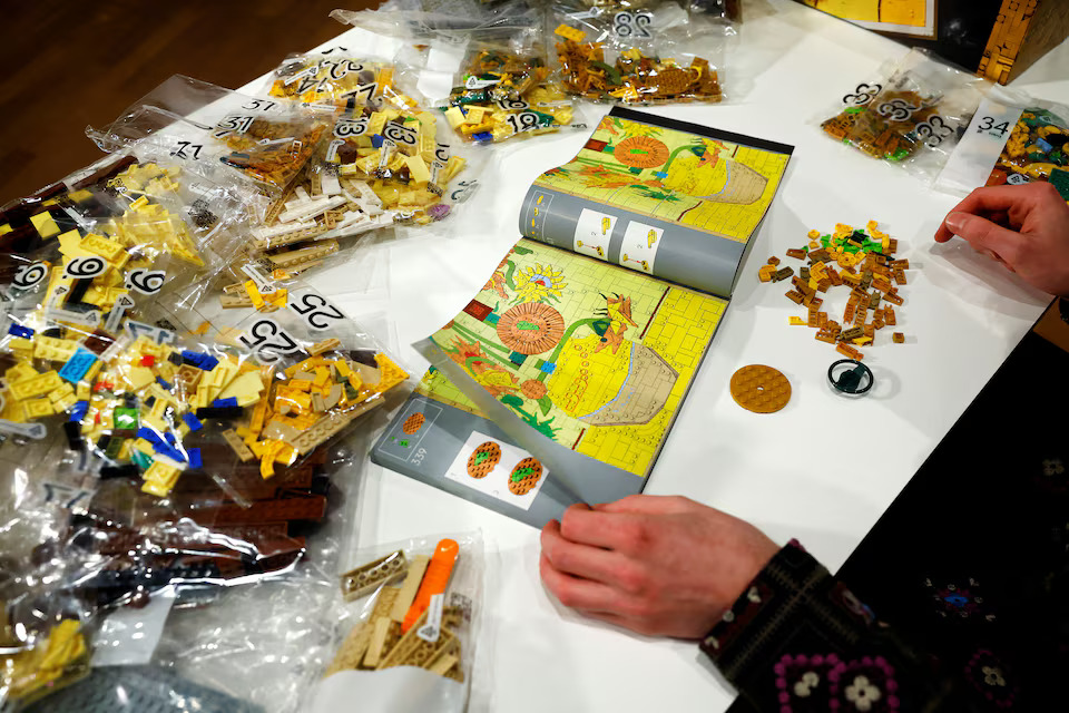 [12/15]LEGO Product Designer Stijn Oom puts bricks together to assemble a LEGO brick version of Van Gogh's Sunflowers painting at Van Gogh Museum in Amsterdam, Netherlands, February 28, 2025. Photo: Reuters