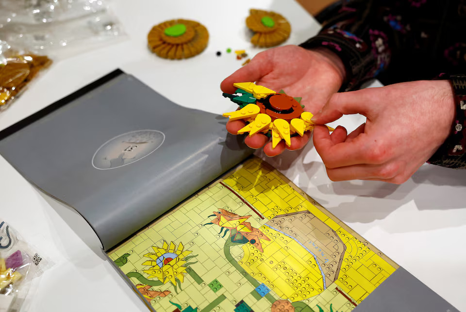 [5/15]LEGO Product Designer Stijn Oom puts bricks together to assemble a LEGO brick version of Van Gogh's Sunflowers painting at Van Gogh Museum in Amsterdam, Netherlands, February 28, 2025. Photo: Reuters