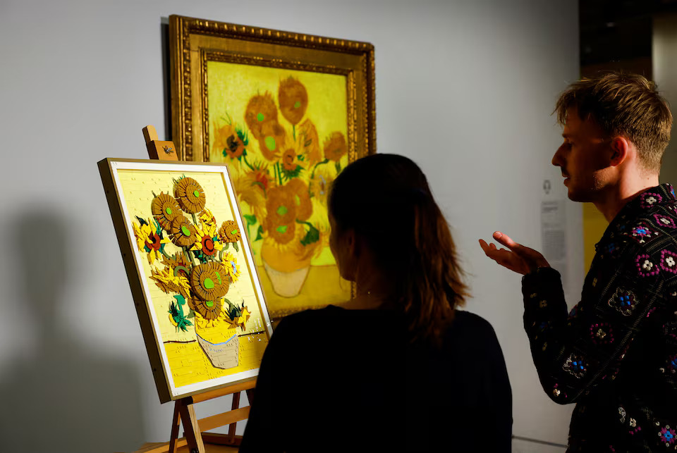 [2/15]Curator at Van Gogh Museum Nienke Bakker and LEGO Product Designer Stijn Oom look at a LEGO brick version of Van Gogh's Sunflowers painting next to the original version of the painting displayed at Dutch Van Gogh Museum in Amsterdam, Netherlands, February 28, 2025. Photo: Reuters