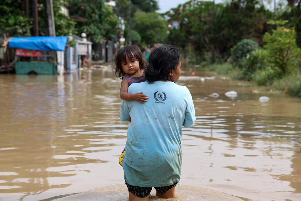 [5/10]A girl looks on as she is carried by her mother as floods hit the residential area following heavy rains in Bekasi, on the outskirts of Jakarta, Indonesia, March 4, 2025. Photo: Reuters