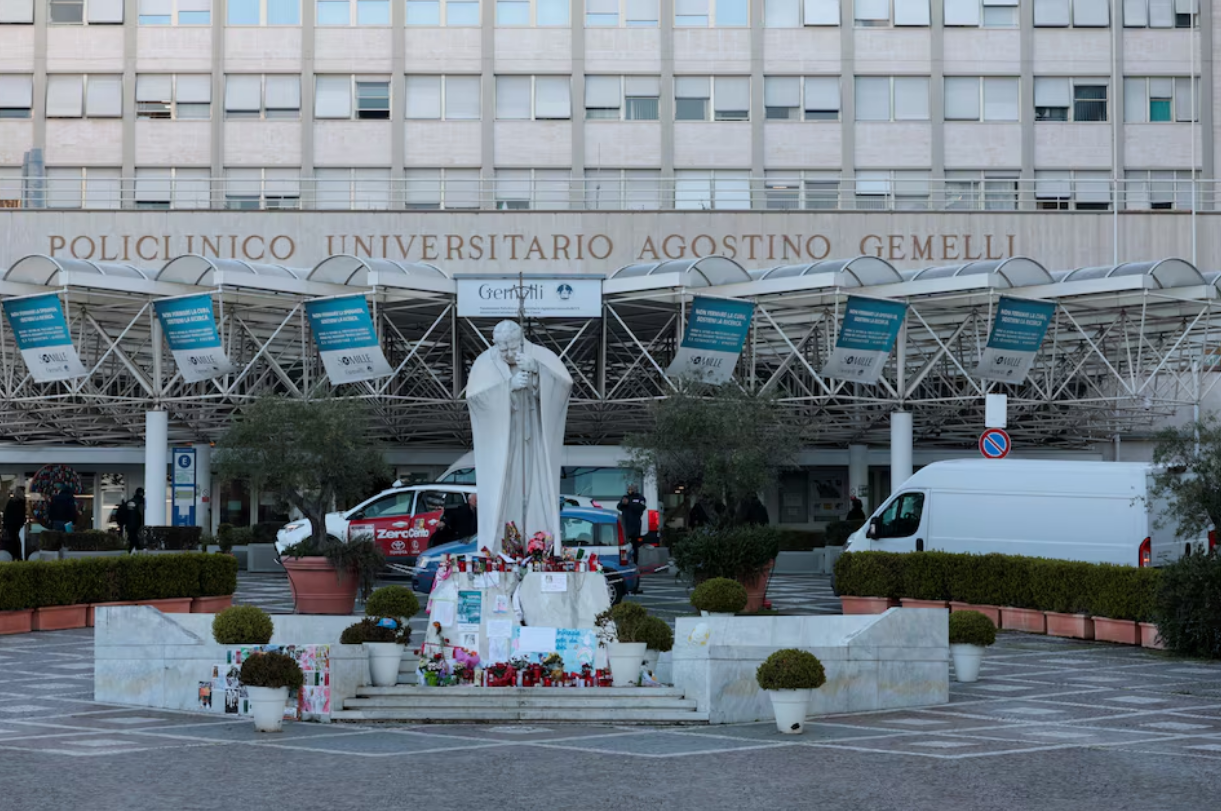 Messages, candles and flowers are placed near the statue of late Pope John Paul II outside Gemelli Hospital where Pope Francis is admitted for treatment, in Rome, Italy, March 5, 2025. Photo: Reuters