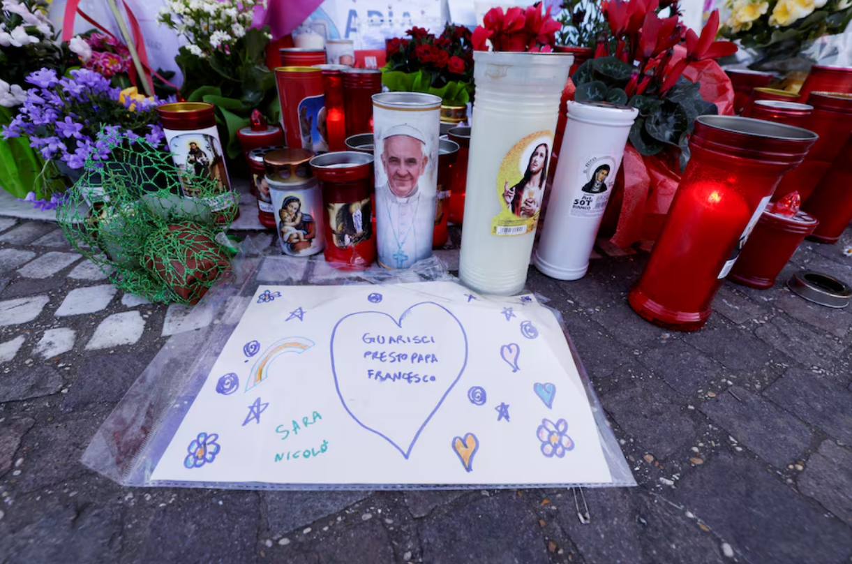 A drawing with a message that reads 'Get well soon Pope Francis' is placed near the statue of late Pope John Paul II outside Gemelli Hospital where Pope Francis is admitted for treatment, in Rome, Italy, March 5, 2025. Photo: Reuters