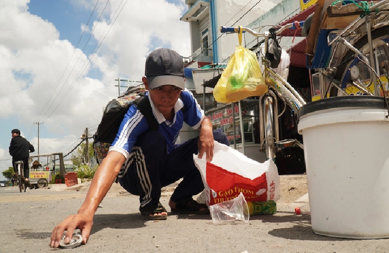 Do collects plastic bottles and metal cans on his five-km commute to and from school. Photo: Thanh Huyen / Tuoi Tre