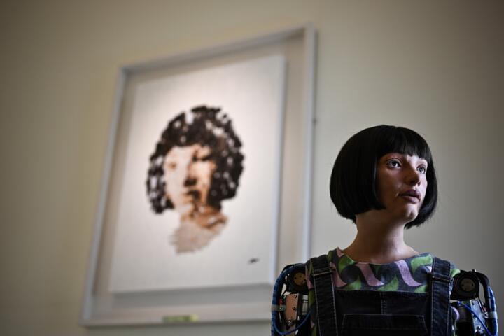 Ultra-realistic AI robot Ai-Da poses in front of a painting she made during the press preview of the London Design Biennale 2023 at Somerset House, central London, on June 1, 2023. Photo: AFP