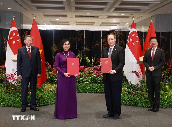 Vietnamese Party General Secretary To Lam (L, 1st) and Singaporean Prime Minister Lawrence Wong witness the exchange of a signed cooperation agreement on wind power trade between representatives of both sides in Singapore, March 12, 2025. Photo: VNA