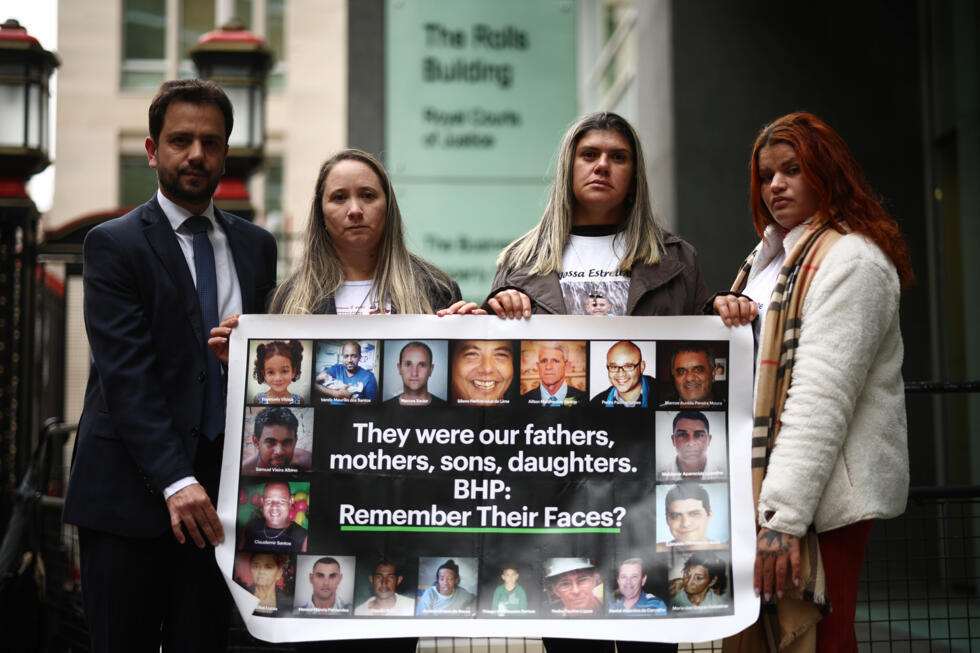 Brazilian city Mariana mayor Juliano Duarte poses with a banner with (2ndL-R) Monica dos Santos, Gelvana Rodrigues and Pamela Fernandes outside the High Court's Rolls Building in London on March 13, 2025 as a trial on whether Australian mining giant BHP is liable for one of Brazil's worst environmental disasters concludes, with hundreds of thousands of victims demanding billions in compensation. Photo: AFP