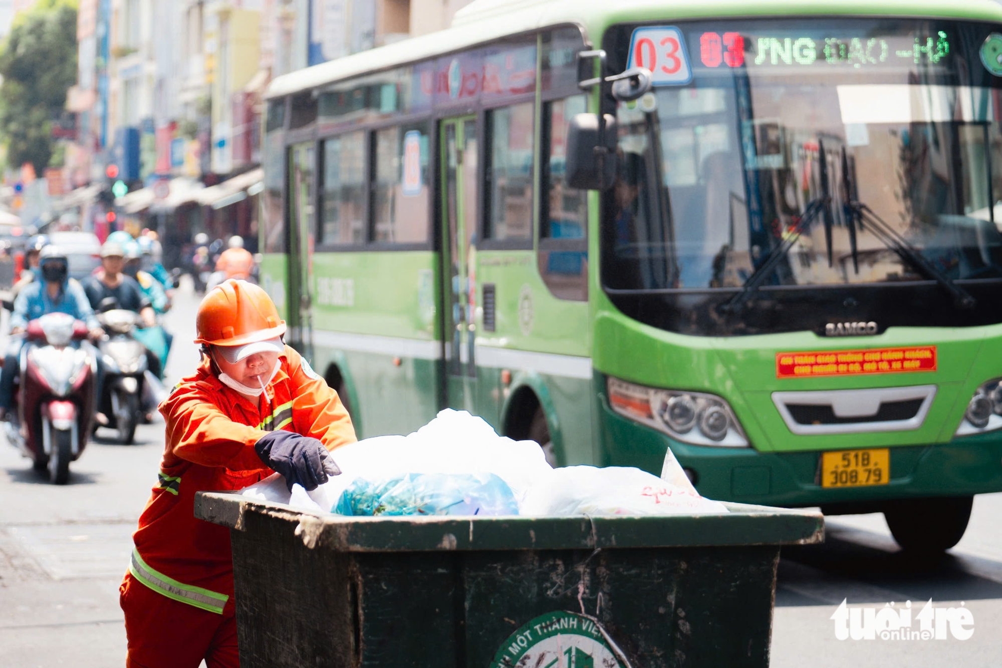 A sanitation worker collects trash under the blazing sun on Phan Dinh Phung Street in Phu Nhuan District, Ho Chi Minh City. Photo: Thanh Hiep / Tuoi Tre