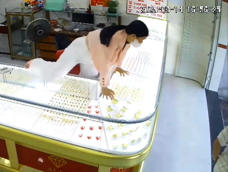 Captured from surveillance footage, this image shows Tran Thi T.M., the owner of the Mai Kim gold shop in Ba Ria-Vung Tau Province, southern Vietnam, leaping over the glass counter to chase the robber Bui Chi Binh, March 14, 2025.