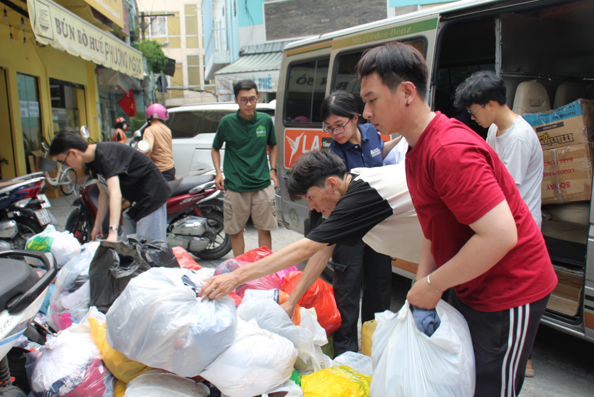 Volunteers load clothes onto a vehicle for delivery to a ‘zero-dong shop.’ Photo: Bao Tran / Tuoi Tre