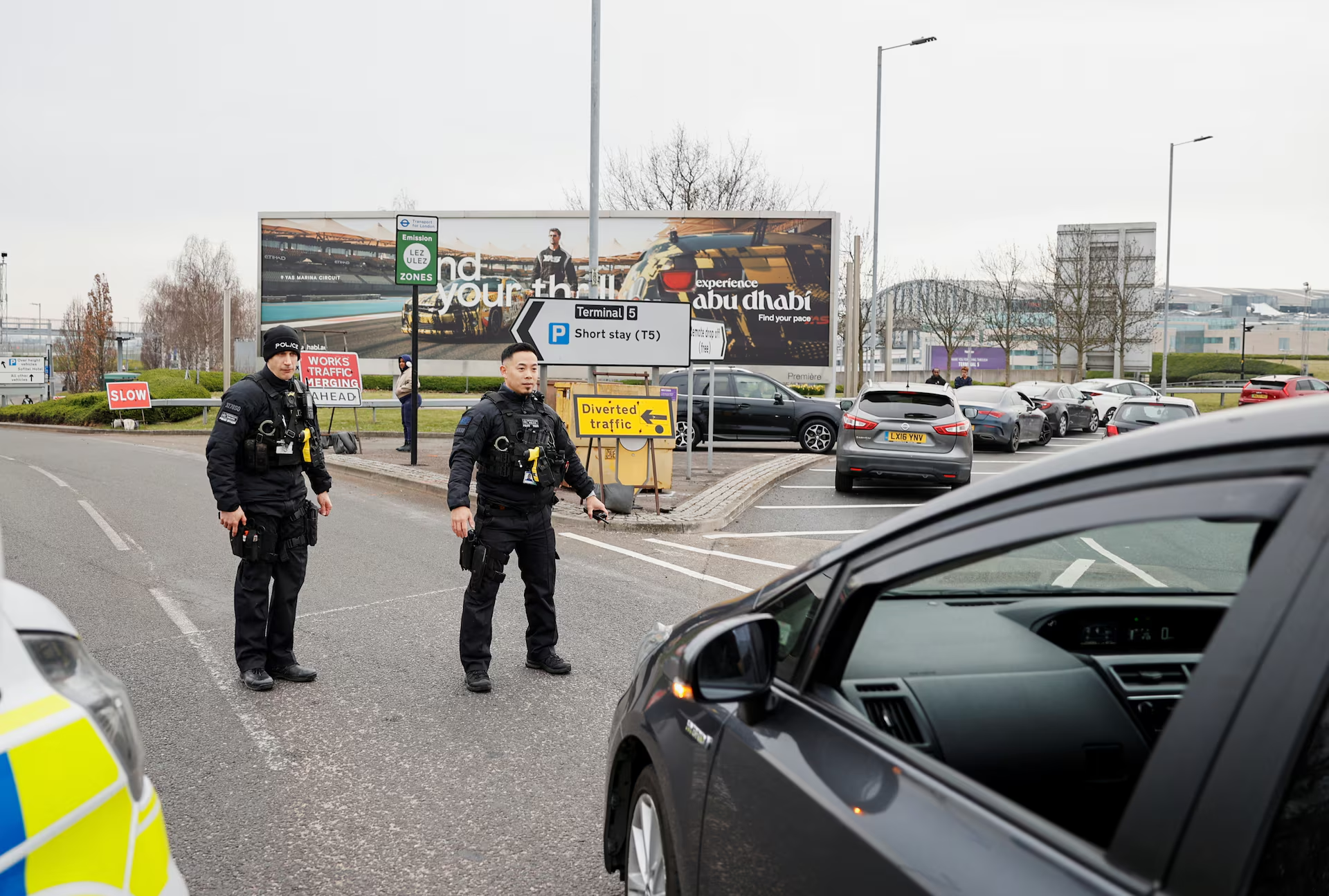 Members of the police stand near traffic outside Terminal 5 at the Heathrow International Airport after a fire at a nearby electrical substation wiped out power at the airport, near London, Britain, March 21, 2025. Photo: Reuters