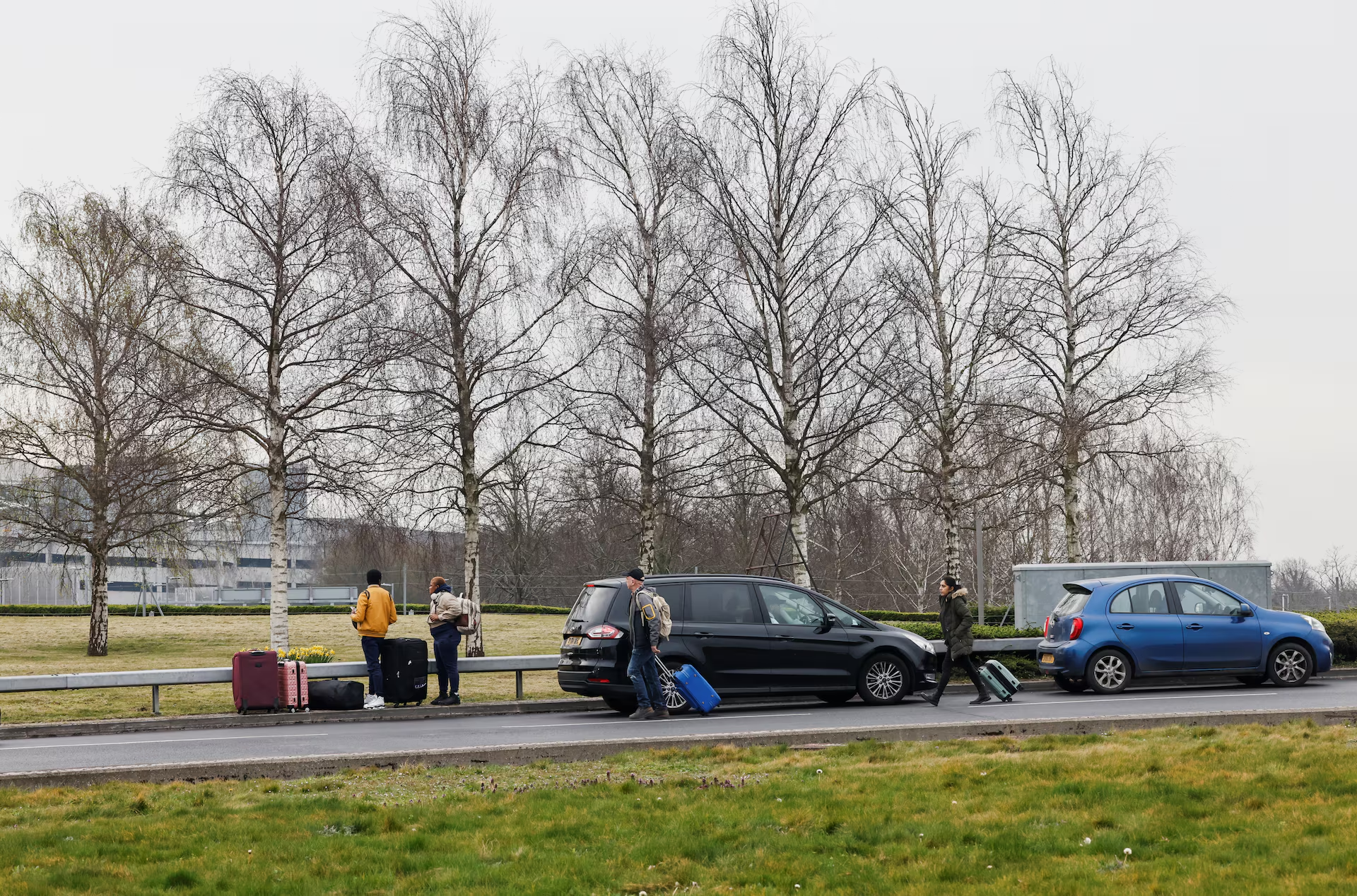 People with bags walk outside Terminal 5 at the Heathrow International Airport after a fire at a nearby electrical substation wiped out power at the airport, near London, Britain, March 21, 2025. Photo: Reuters