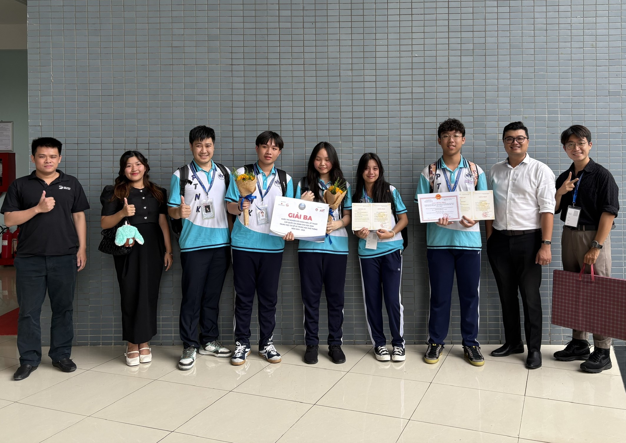 Le Dinh Luc (L), CEO and founder of DOL English, poses with students from his alma mater, High School for Gifted Students under the Vietnam National University-Ho Chi Minh City.